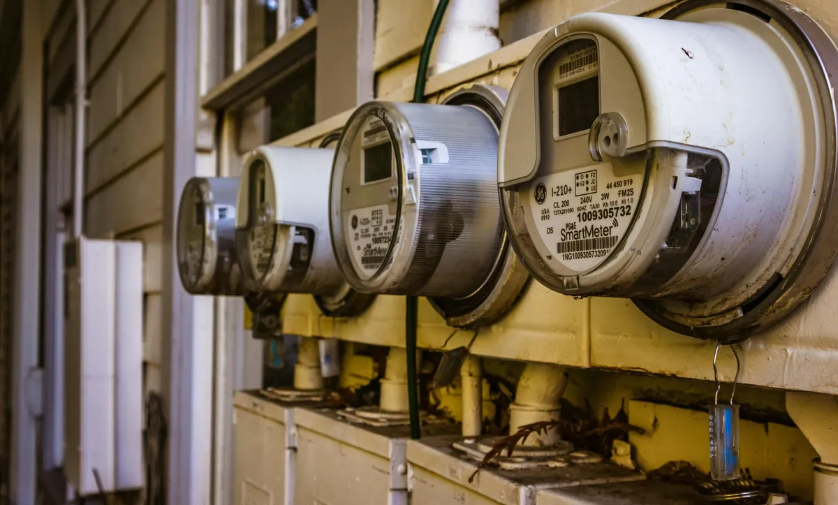 Four residential natural gas meters installed along the exterior of a home — D&S Utility Services Maryland